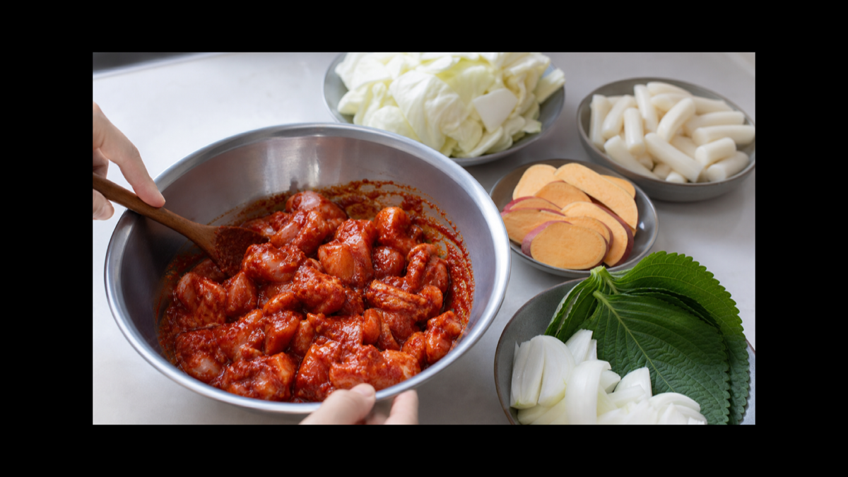 한입 크기의 닭다리살에 닭갈비 양념을 버무리고 채소와 떡을 준비한 모습
